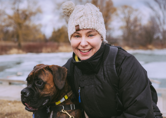 a female with her boxer dog during winter outdoors