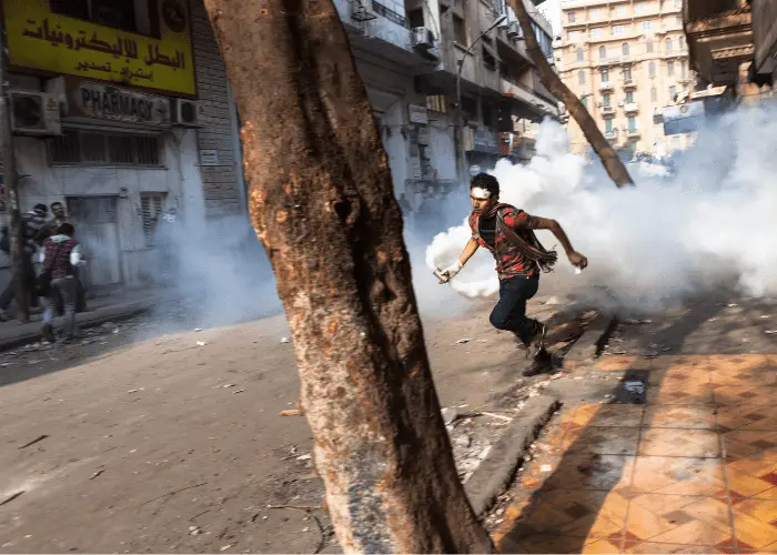 Are Dogs Immune to Tear Gas? 4 a man holding a tear gas exploded during a riot