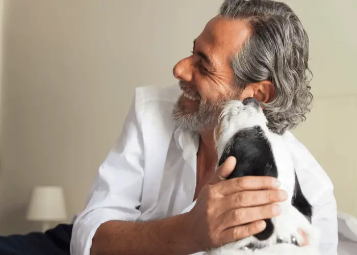 7 Reasons Why Dogs Lick Ears (OF OTHER DOGS & HUMANS) 4 dog licking male owner